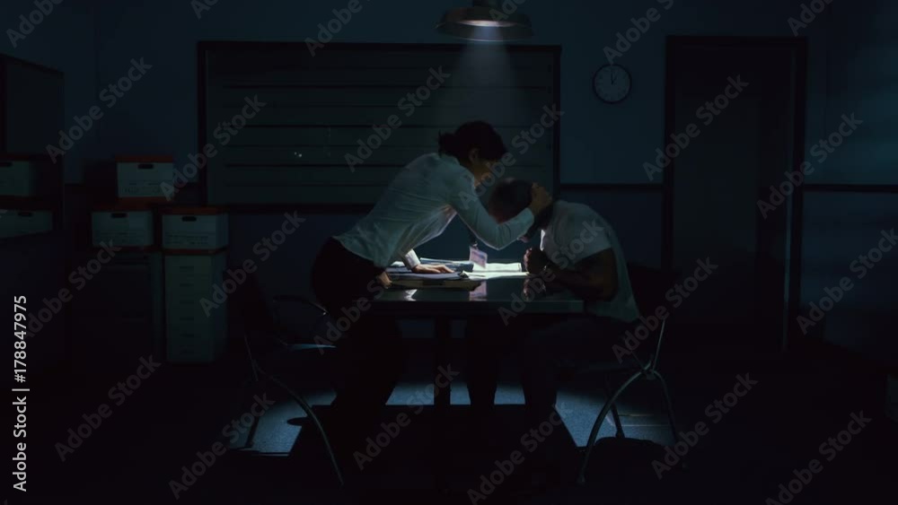 Criminal in handcuffs being interrogated by female police detective Criminal in handcuffs being interrogated by female police detective