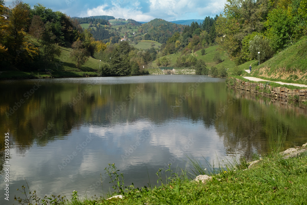 A picturesque lake surrounded by mountains. Autumn forest reflected in the water.