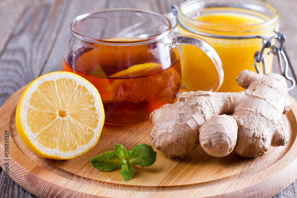 A glass cup of natural tea with ginger, lemon, mint and honey on wooden rustic background. Healthy drink. Healthy concept. Prevention of diseases. Autumn, winter tea A glass cup of natural tea with ginger, lemon, mint and honey on wooden rustic background. Healthy drink. Healthy concept. Prevention of diseases. Autumn, winter tea