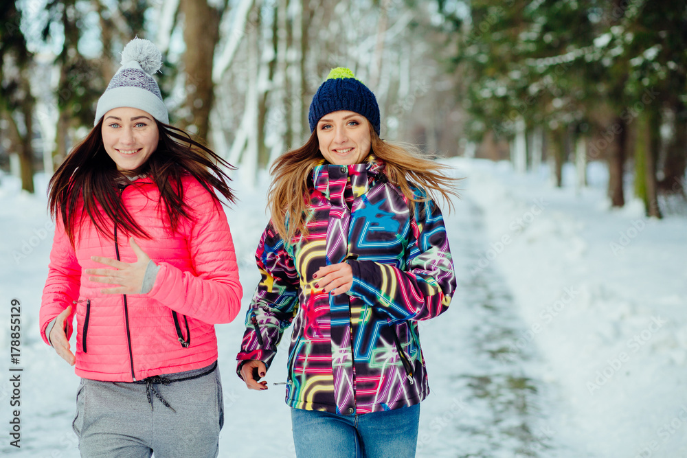 Young attractive women running  in the winter park