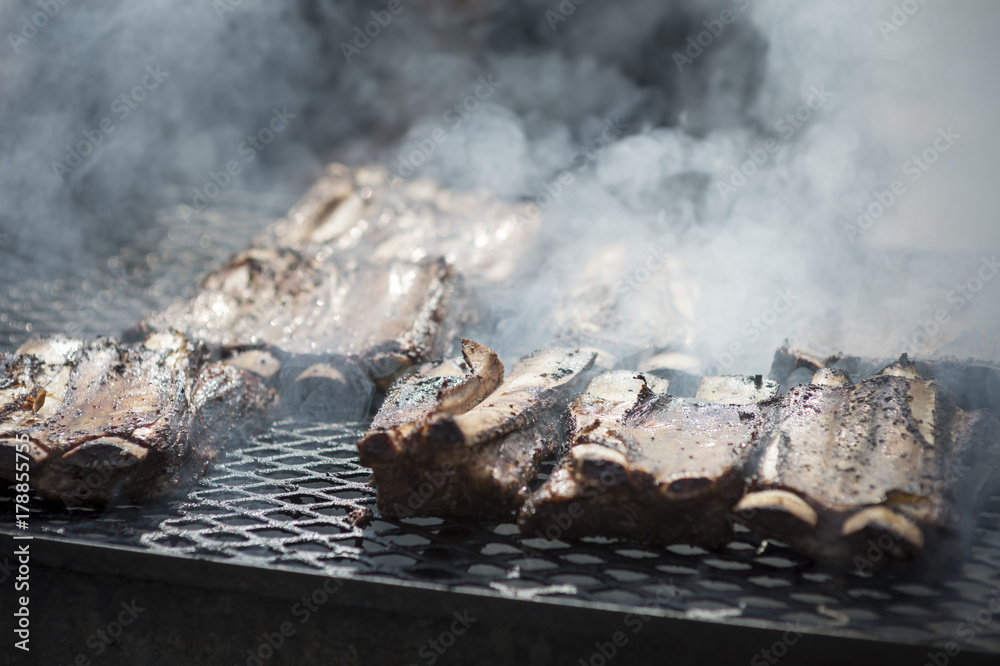 Ribs cooking on a smoky barbecue grill Ribs cooking on a smoky barbecue grill