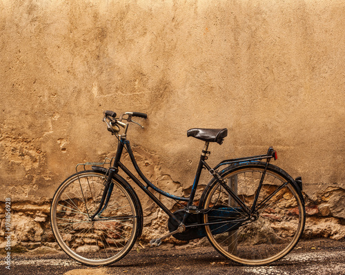  Verona.  Retro styled image of vintage old  Bicycle on Street in Italy, parking near wall with copy space. © nataliazakharova