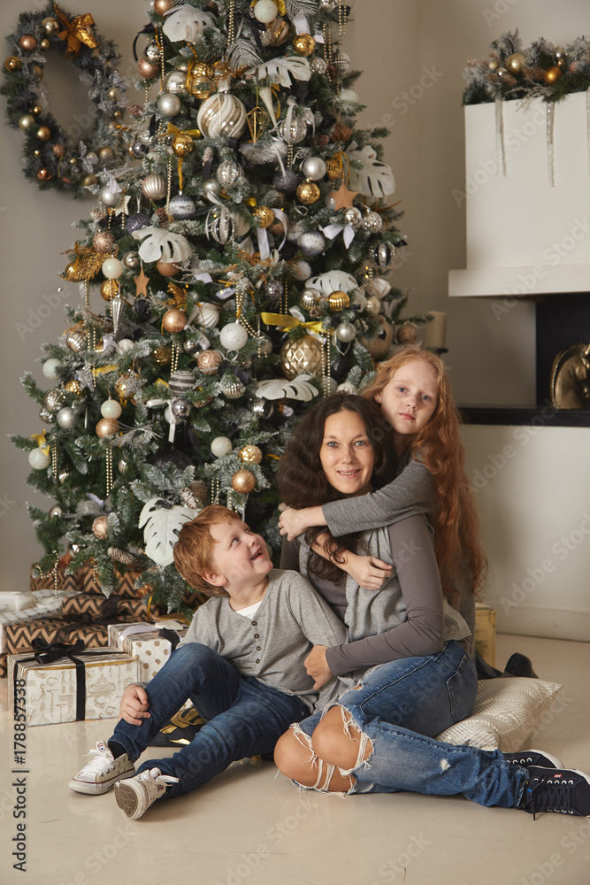 Mom with children on the background of a Christmas tree