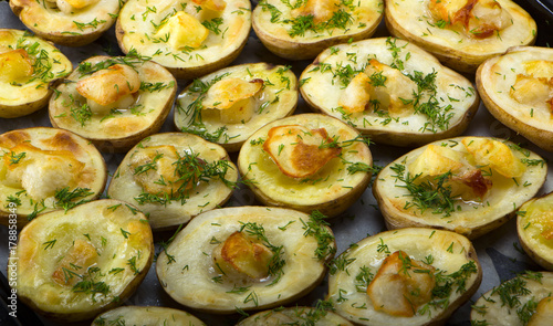baked potatoes in a baking sheet on a wooden table top view