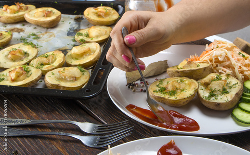 baked potatoes in a baking sheet on a wooden table top view photo