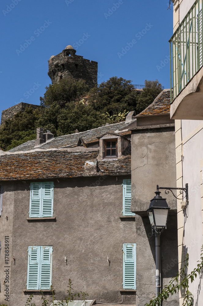 Corsica, 28/08/2017: lo skyline di Nonza, villaggio sulla costa occidentale di Capo Corso, con le sue case antiche, i tetti e la sua torre genovese del XVI secolo