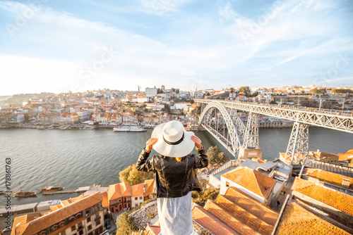 Fotografi Young woman tourist enjoying beautiful landscape view on the old town with river
