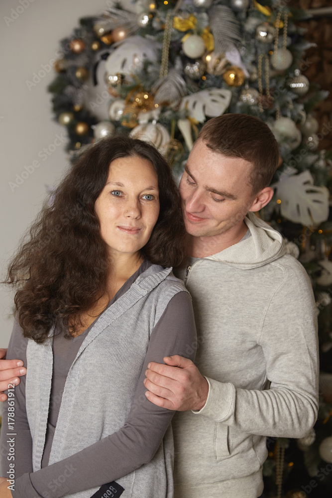 Young couple on a christmas tree background Young couple on a christmas tree background