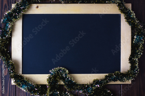 Blackboard with place for your text, surrounded by christmas garland. photo