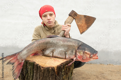 Caucasian girl in red kerchief and big fish. Selective focus. photo