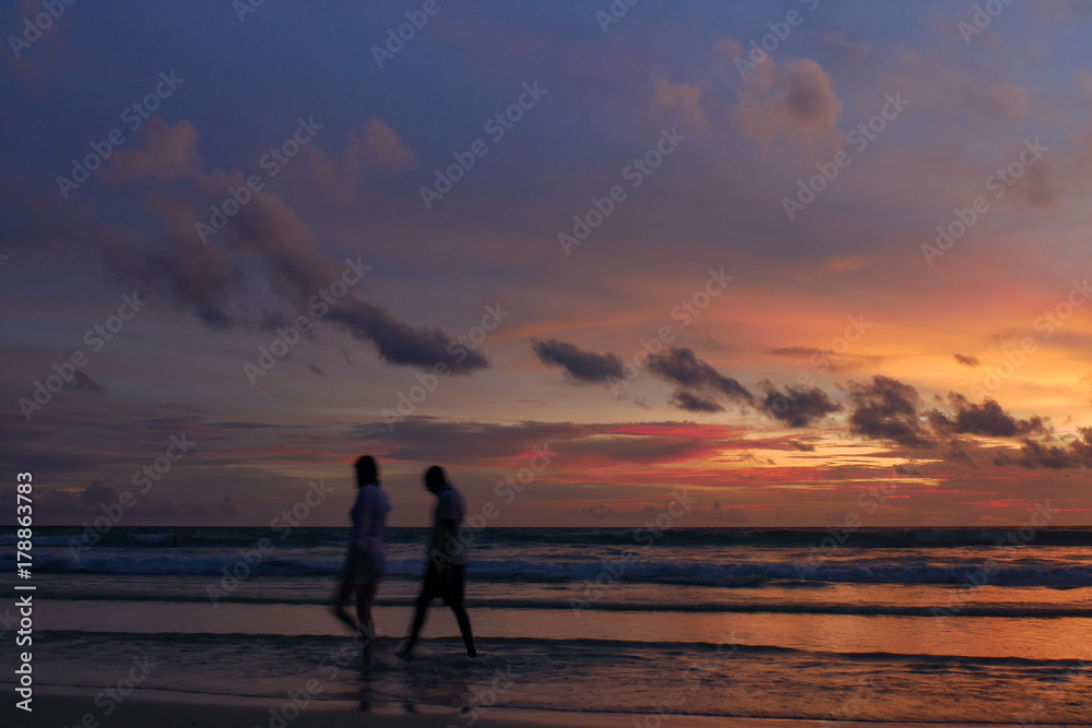 blurred people at the beach with twilight cloudy sky.