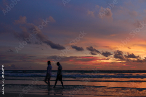 blurred people at the beach with twilight cloudy sky. © kae2nata