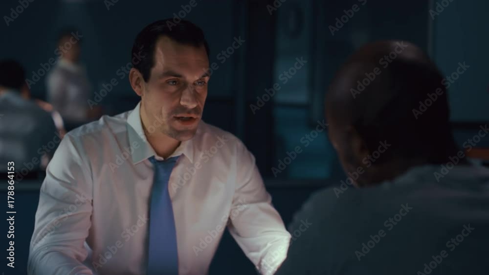 Police detective in interview room interrogating a suspect Police detective in interview room interrogating a suspect