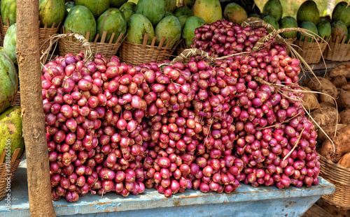 Fototapeta Naklejka Na Ścianę i Meble -  Red onion and mango on display for a sale. Close up. Market stall. Organic food.