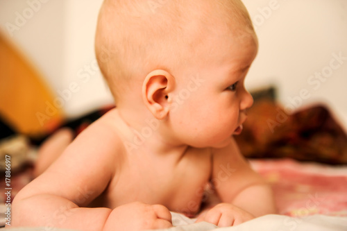 Caucasian boy lies on the bed. Children's emotions. photo