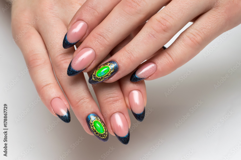 New Year's blue French manicure with a gold brooch with a green stone New Year's blue French manicure with a gold brooch with a green stone