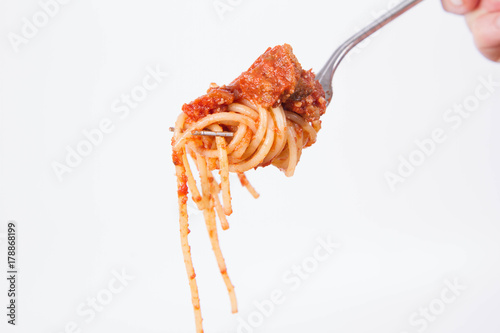 Spaghetti bolognese on a fork on a white background