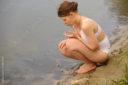 A semi-nude Caucasian girl resting on the lake during pregnancy. The concept of a healthy lifestyle. Lingerie for pregnant women. photo