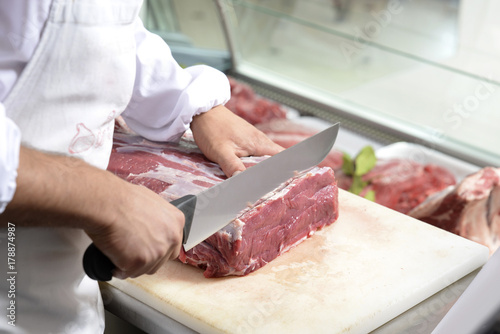 butcher cuts a steak photo