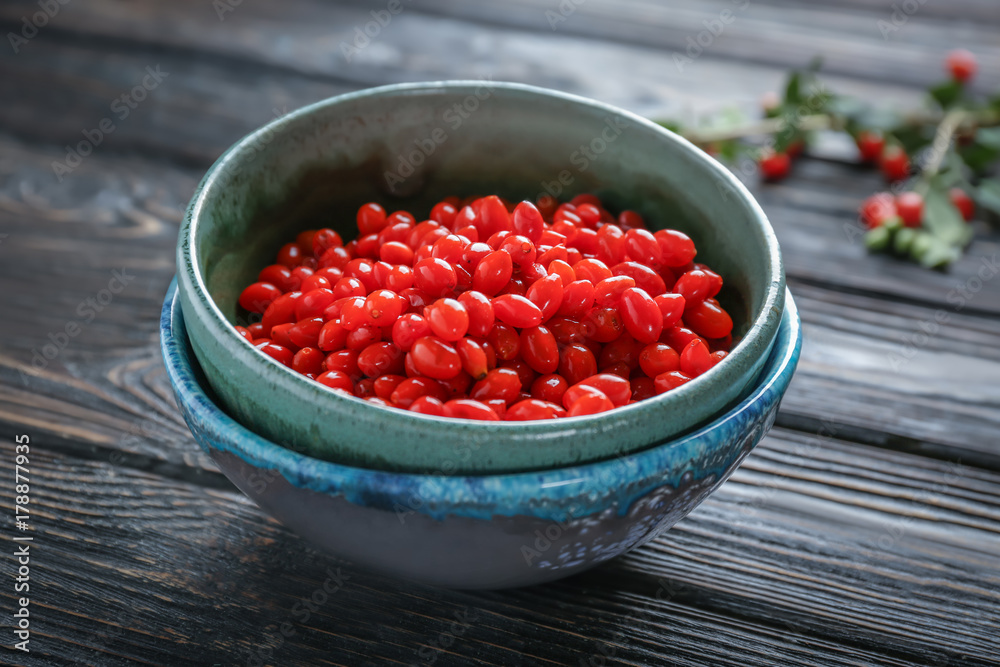 Bowl with goji berries on wooden table