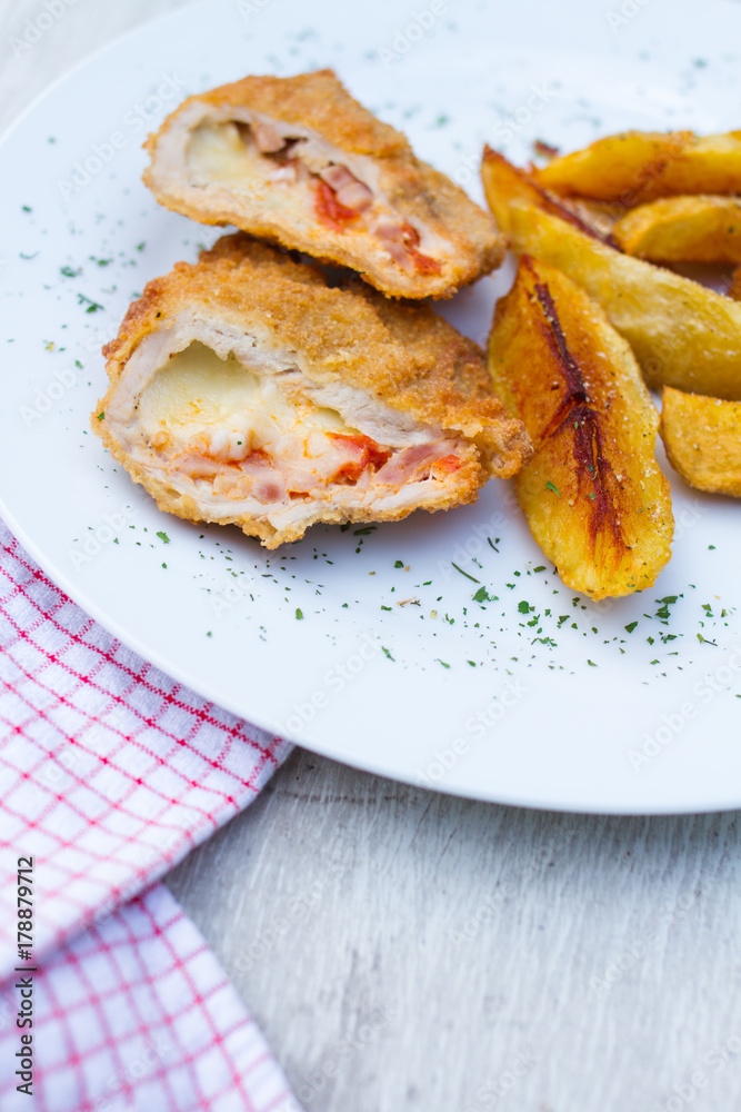 baked potato and slice of veal or other light meat, coated in breadcrumbs and fried