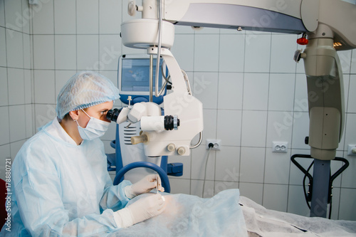 Surgeon with operating system of laser vision correction in the operating room. Ophthalmology operation process