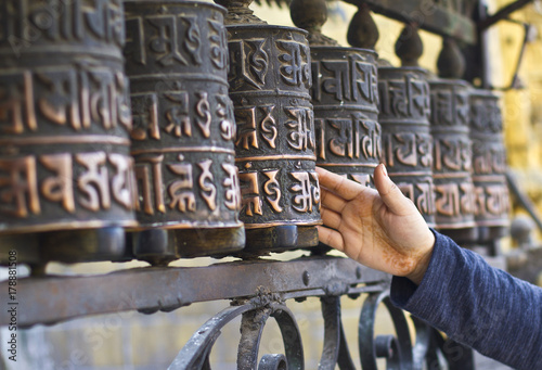 Unknown person spins prayers wheels in Kathmandu Nepal. Buddhist prayer wheels