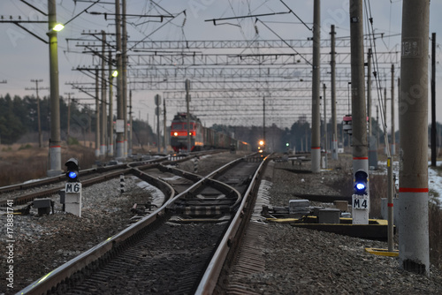 Railway crossroad in the evening, blurred trains at background.