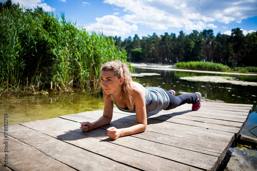 Young woman performing plank position outdoors
