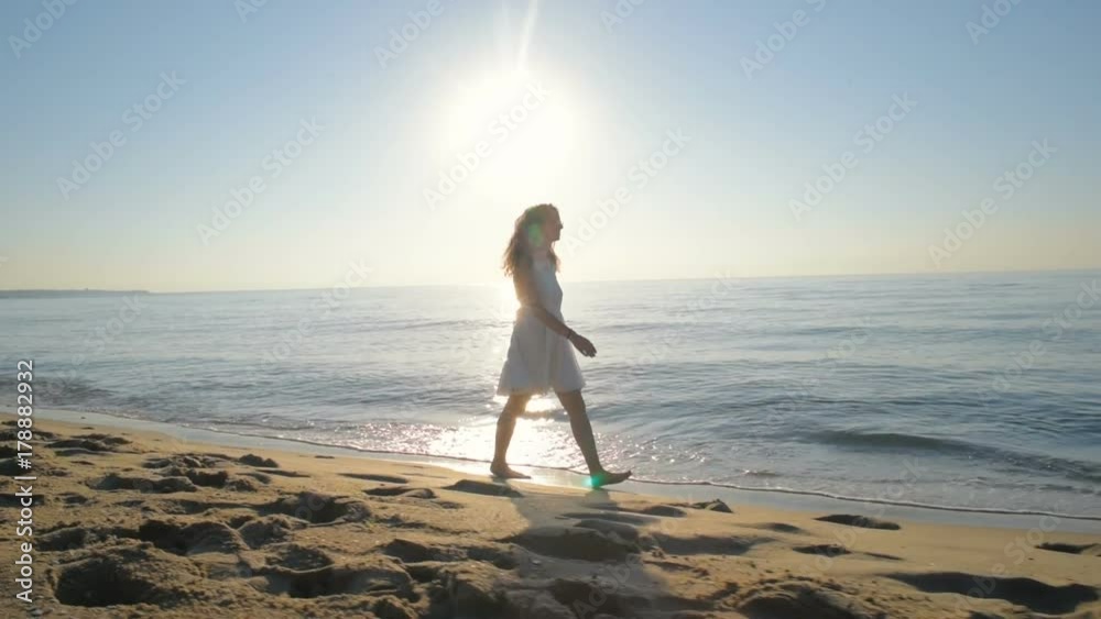 young beautiful female in white dress having fun on beach during sunset or sunrise young beautiful female in white dress having fun on beach during sunset or sunrise