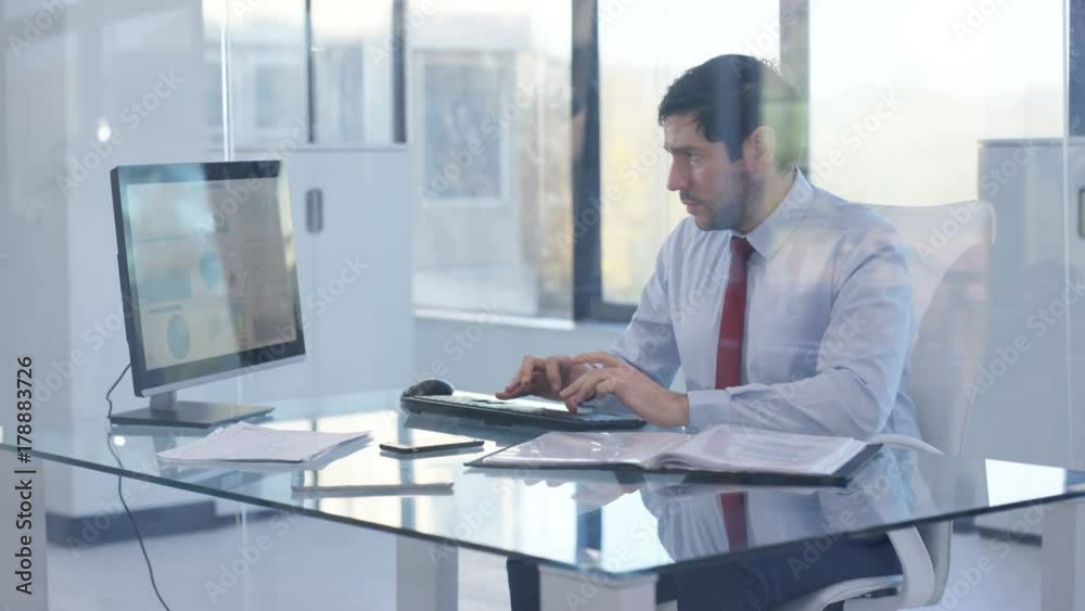  Businessman working on computer at his desk, analyzing financial data