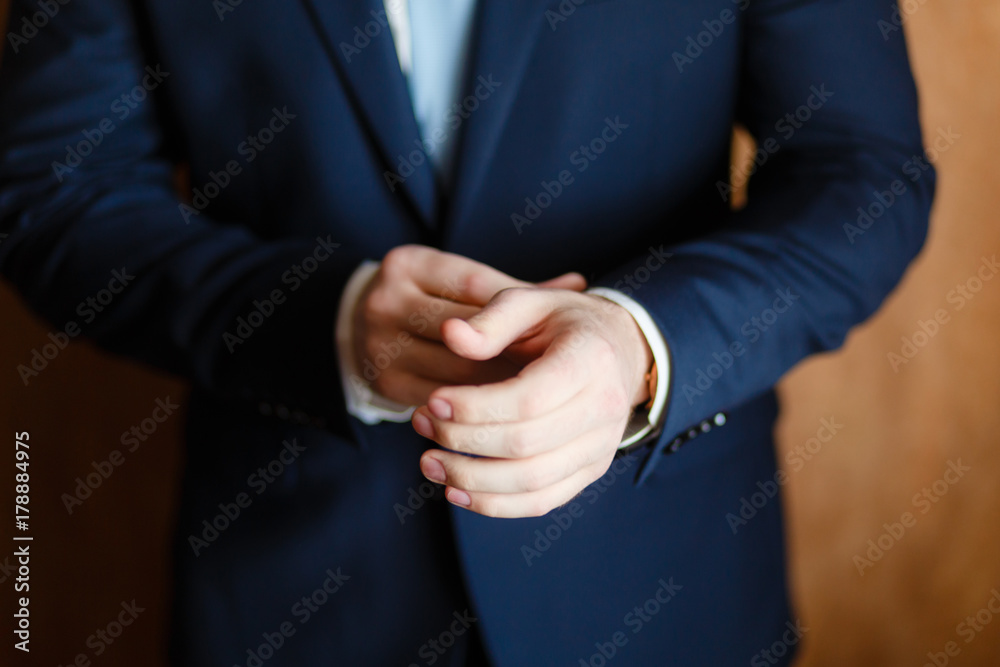 Handsome stylish man dressed in modern formal clothes jacket. Close up of hands of guy in blue jacket, white shirt. Person ready for wedding celebration, graduation or business meeting. Closeup