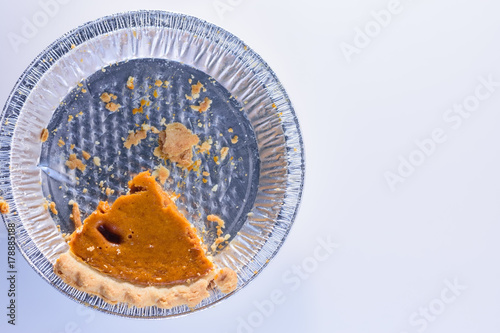 Last piece of pumpkin pie with crumbs in tin