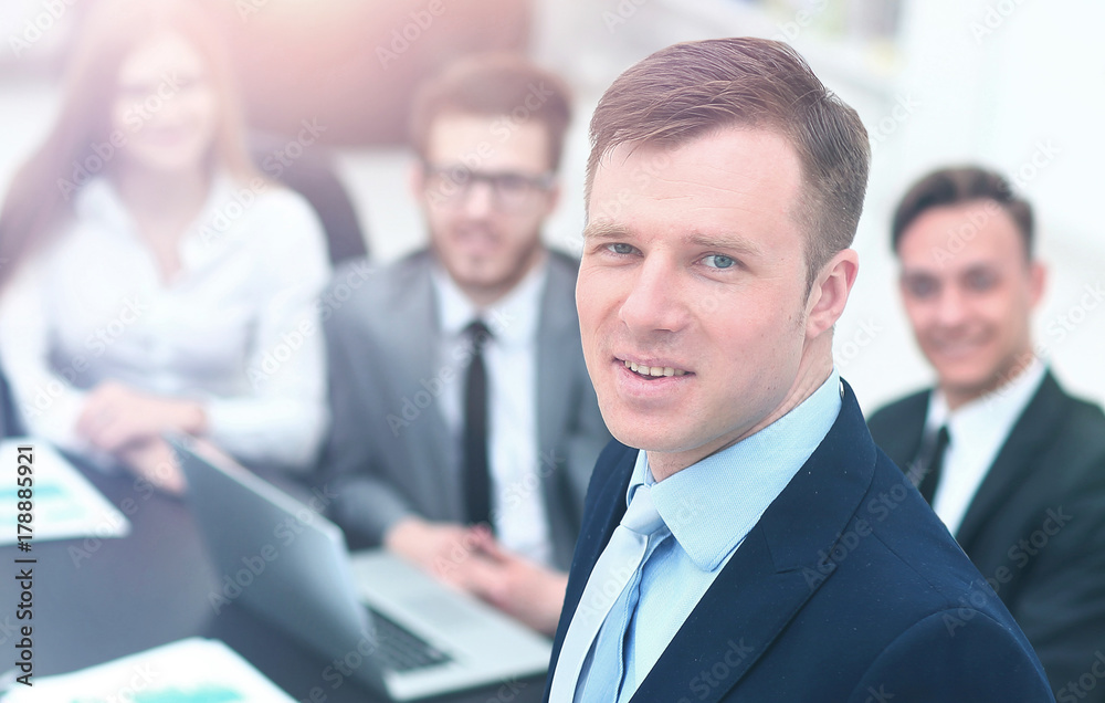 young businessman looking at the camera on the background of his team young businessman looking at the camera on the background of his team