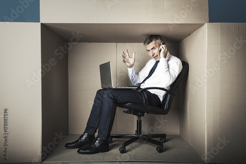 a middle-aged man works in a close office box, he emotionally speaks