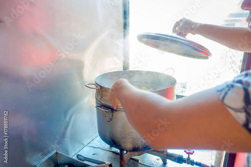 Person cooking a momo food over a metallic tray in the kitchen, type of South Asian dumpling native to Tibet, Nepal, Bhutan and Sikkim in Nepal photo