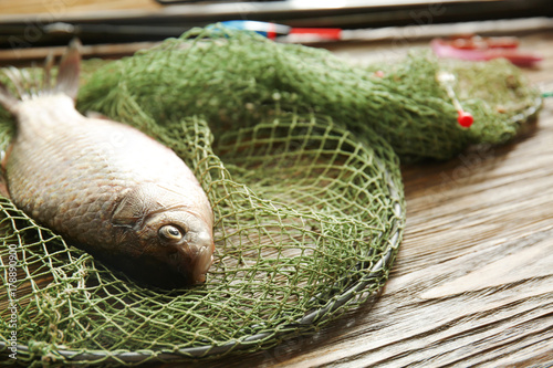 Fresh fish and fishing net on wooden table