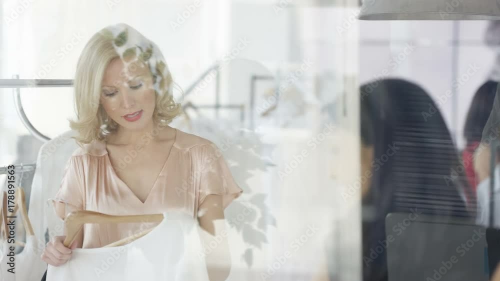 Female customers shopping and clerk giving assistance in fashionable boutique clothing store. Female customers shopping and clerk giving assistance in fashionable boutique clothing store.