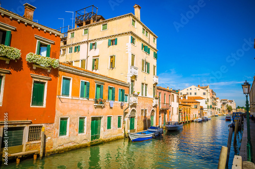 Traditional narrow canal with gondolas in Venice  Italy