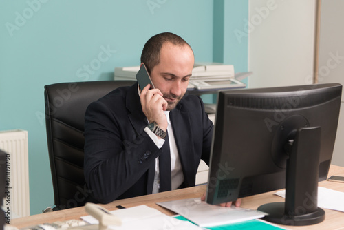 Businessman in Office Talking on Phone © Jale Ibrak