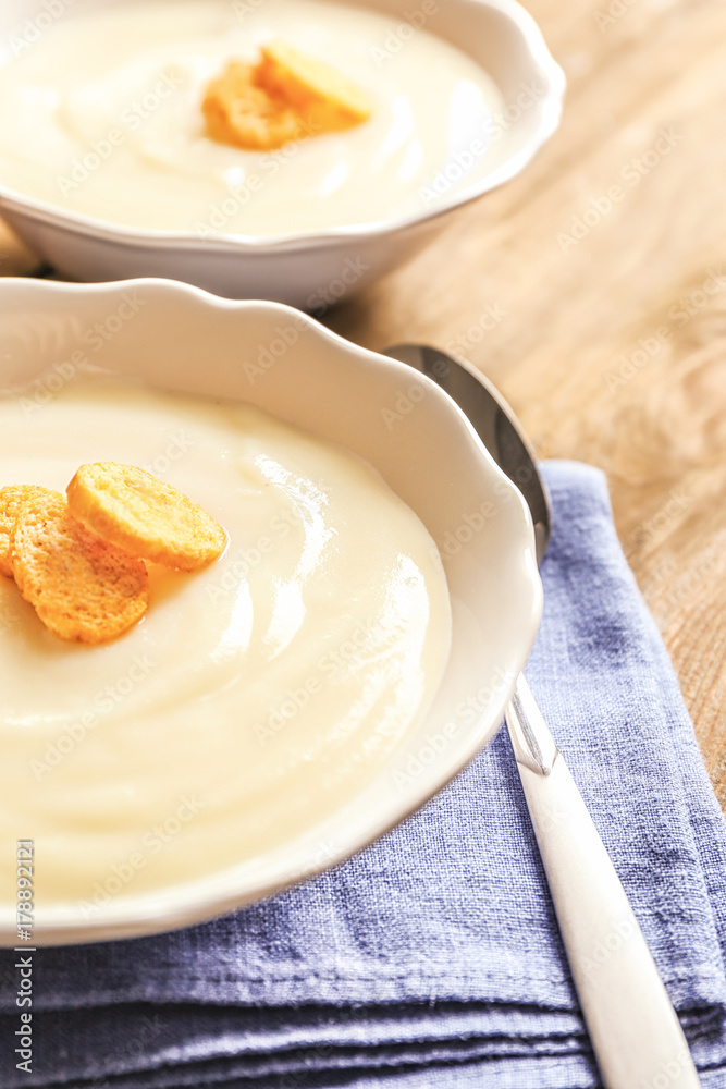 Potato cream soup in bowls on table