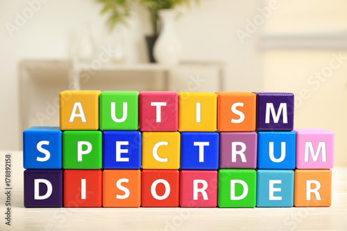 Foto Cubes with text AUTISM SPECTRUM DISORDER on table