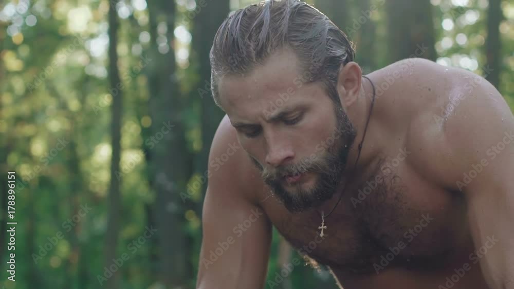 Portrait of strong wet man in the forest. Slowly Portrait of strong wet man in the forest. Slowly
