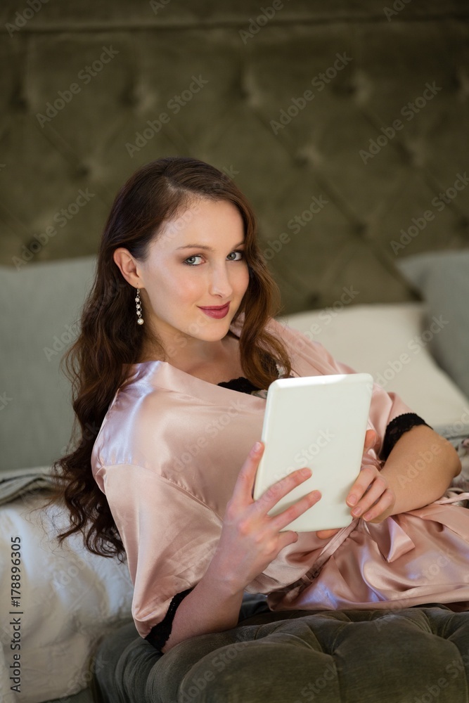 Portrait of beautiful bride using digital tablet while sitting