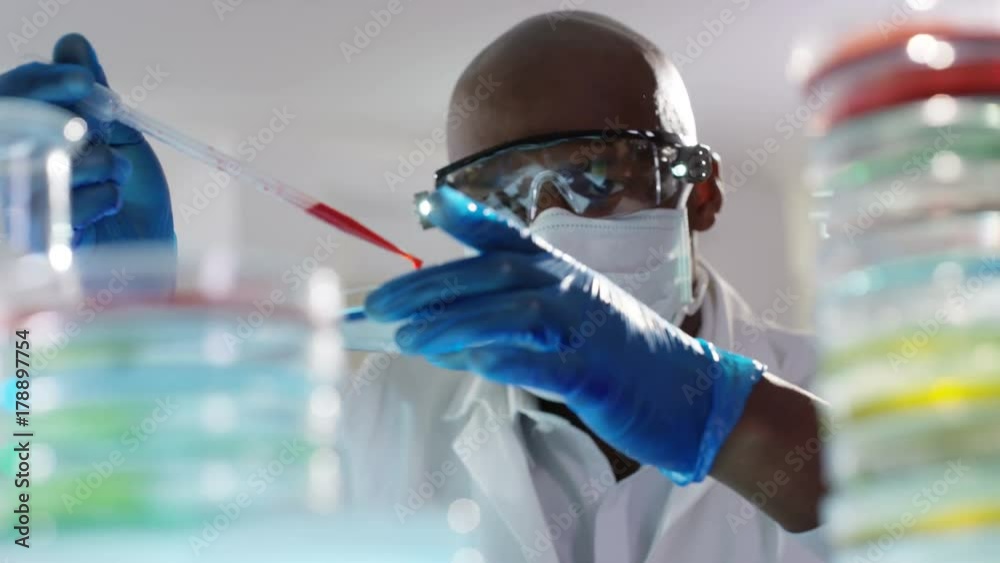 Chemical research scientist working in the lab with colorful liquids