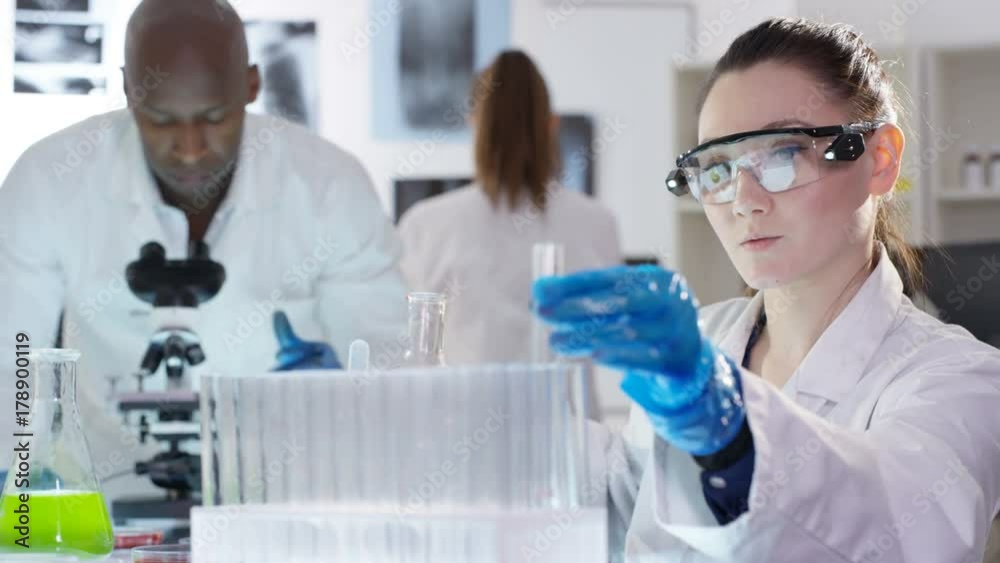 Scientific research team working in the lab with chemicals and test tubes. Scientific research team working in the lab with chemicals and test tubes.