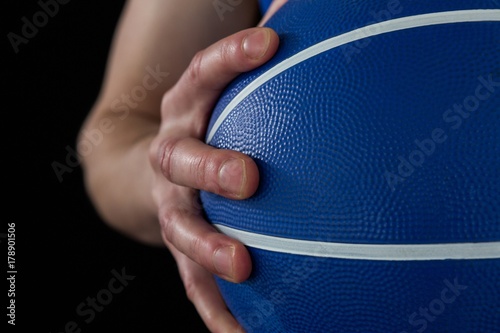 Mid section of player holding basketball © wavebreak3