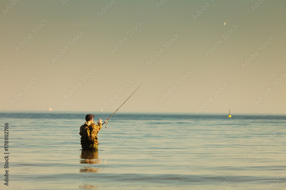 Man standing in water doing extreme fishing