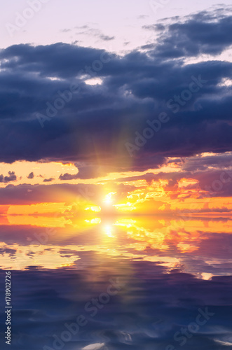 Sunset over the sea with bright sun rays.