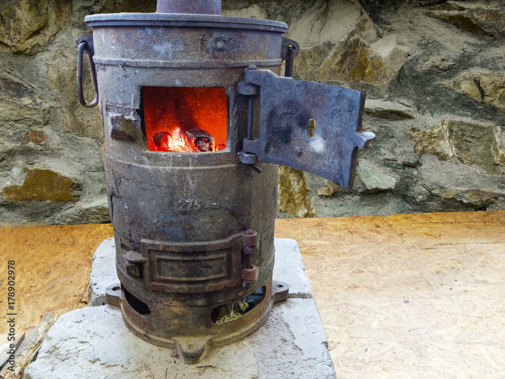 Old cast iron wood burning stove. The fire in the furnace. Stock Photo |  Adobe Stock